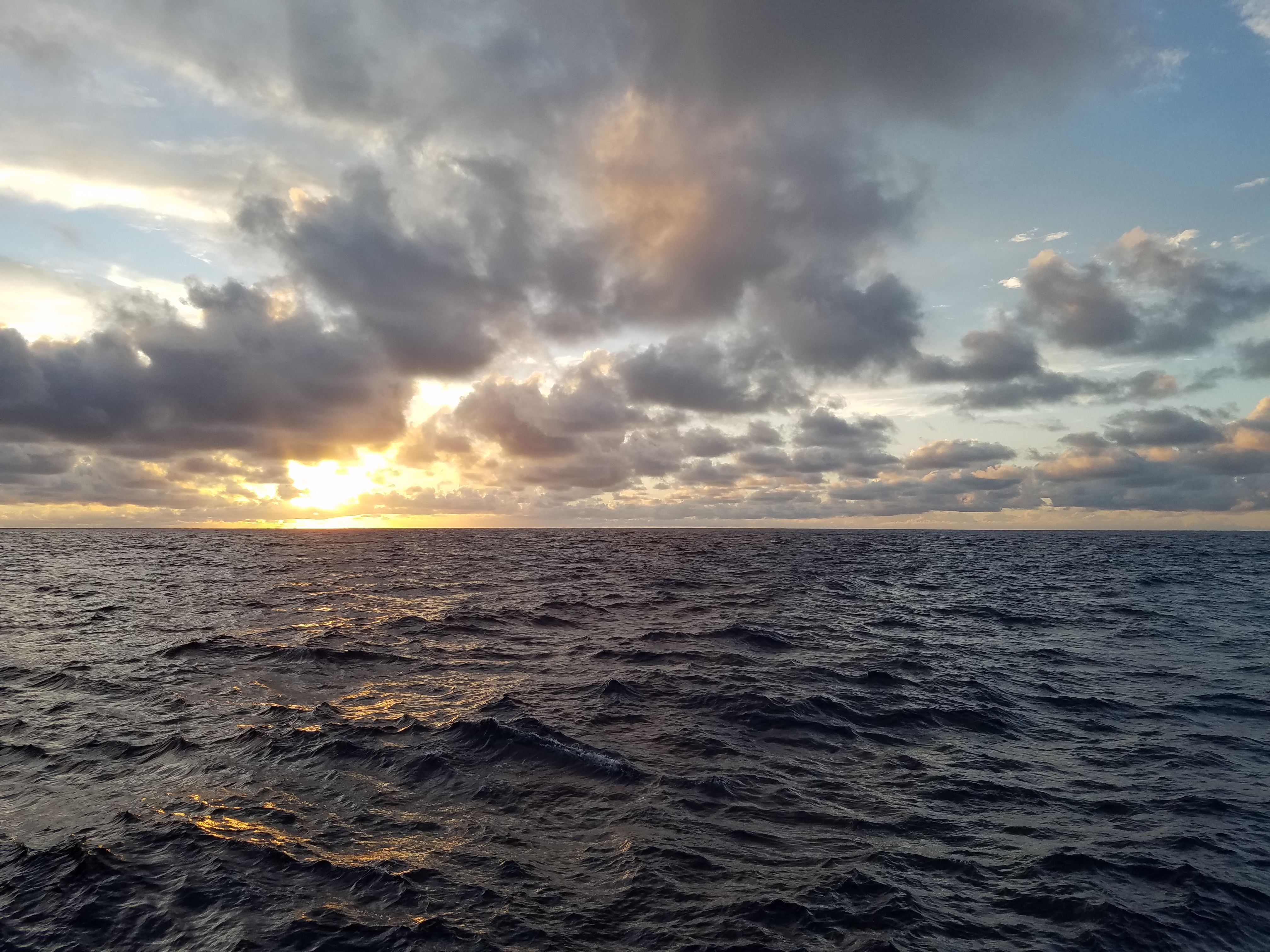 Sonnenuntergang über dem Atlantik mit orangefarbenem Himmel und Meeresoberfläche.