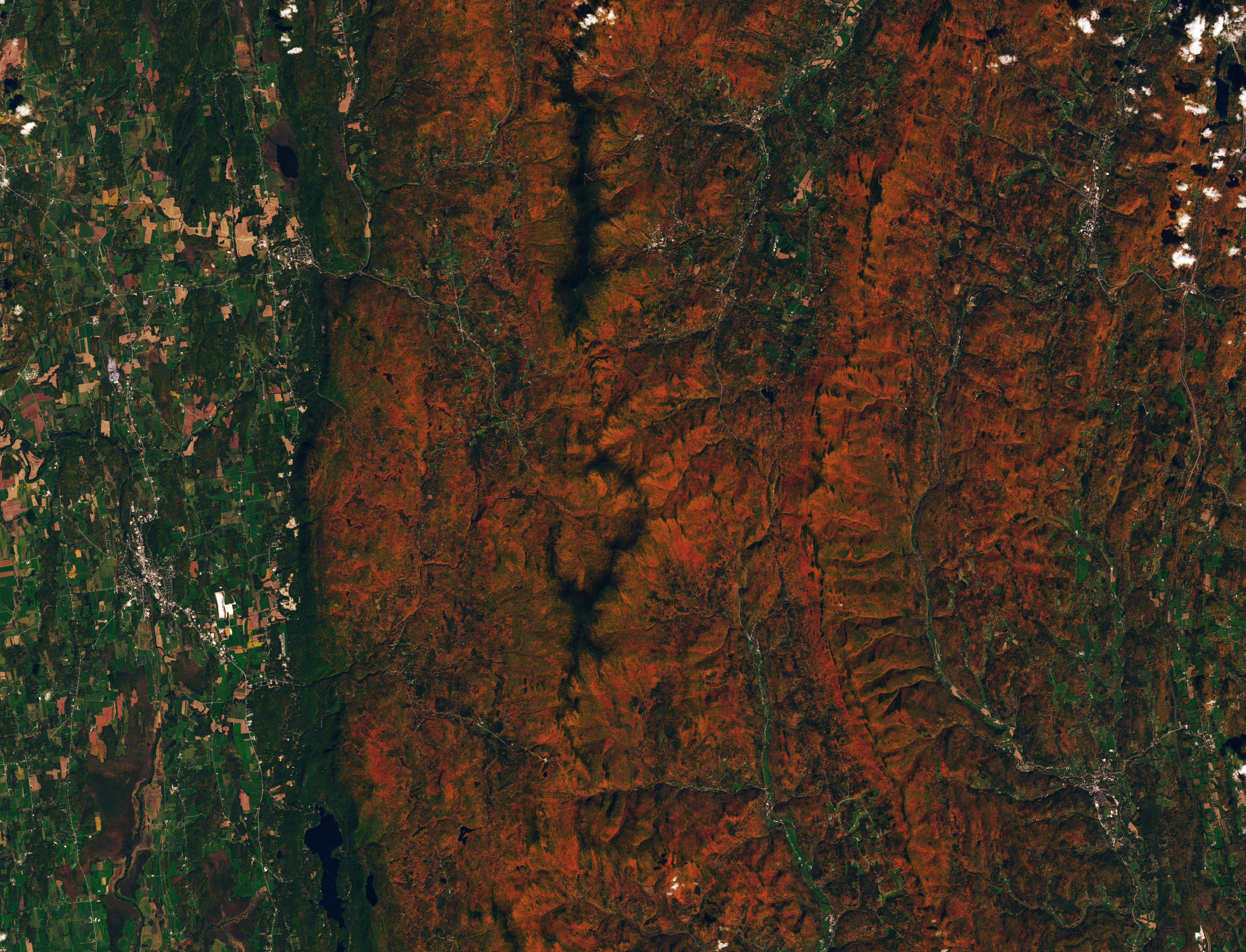 Satellitenbild von Vermont mit roten und orangefarbenen bewaldeten Höhenzügen und grüneren Tälern.